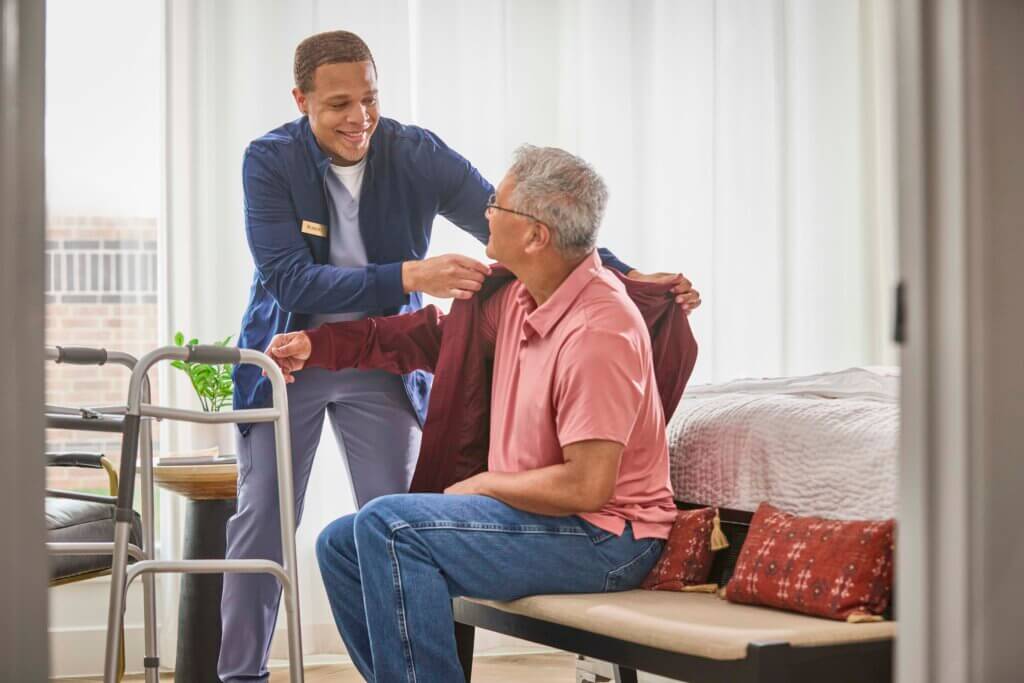 Caregiving helping a patient dress